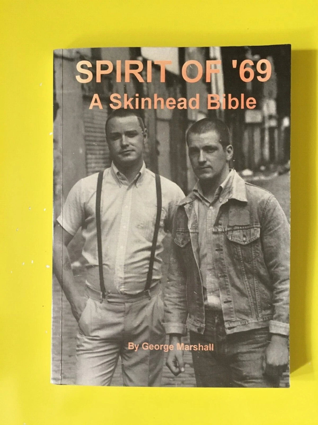 Spirit of '69: A Skinhead Bible by George Marshall - book cover featuring two skinheads in braces and denim on a London street